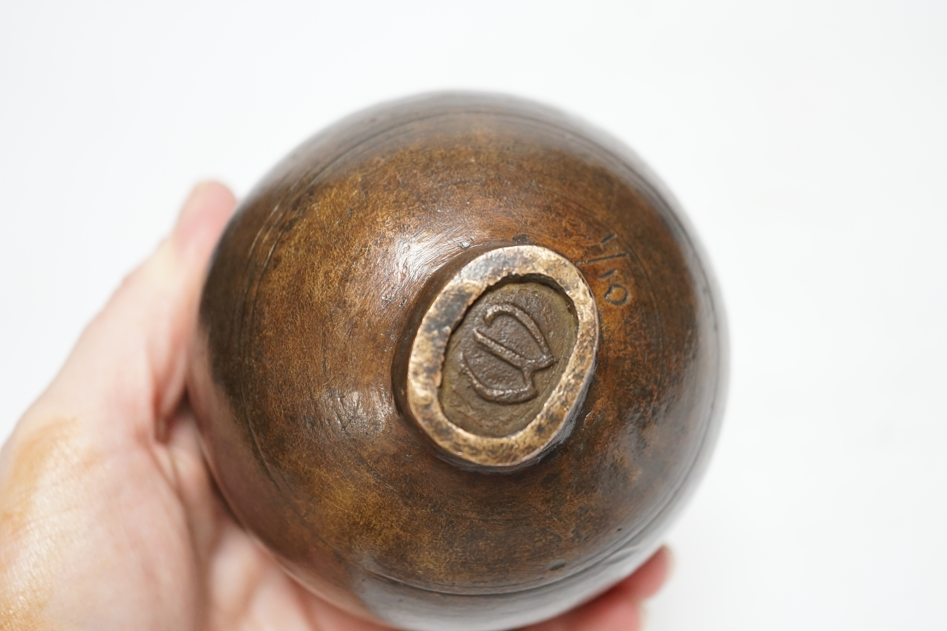 A squat bronze paper weight, the top of two intertwined figures, 8cm high